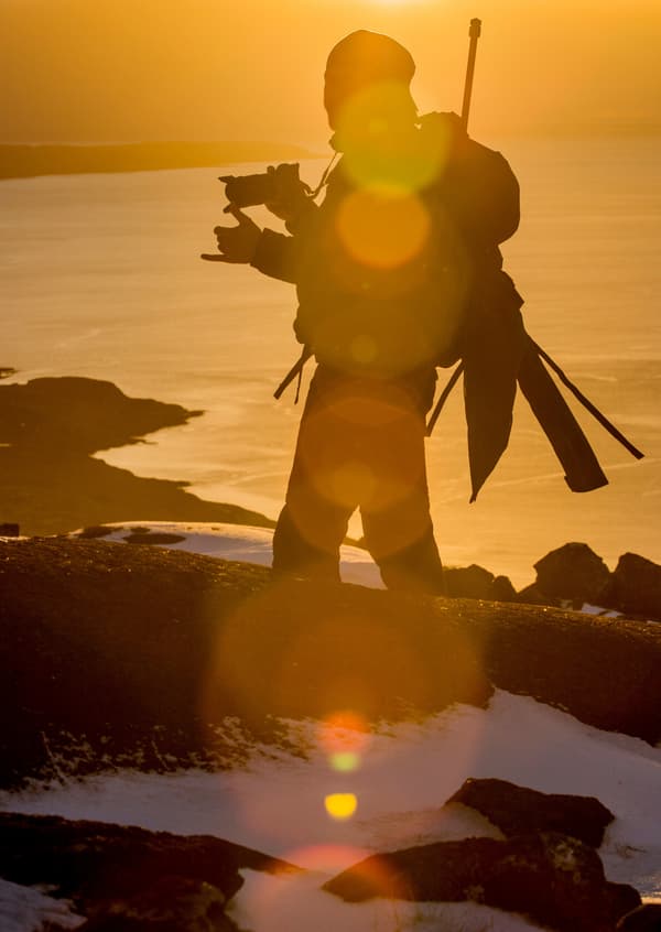 Benjamin Weise photographing at sunset on a rocky coast
